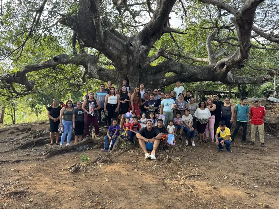 Reef Colman with a village of families gathered under a giant tree after a gift day