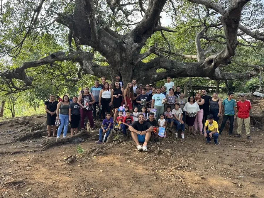 Reef Colman with a village of families gathered under a giant tree after a gift day