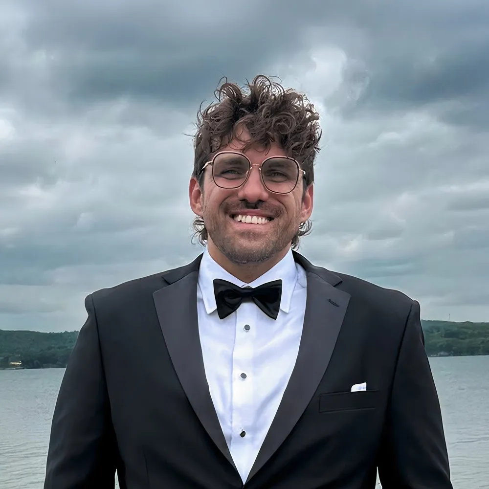 Reef in black tie beside a lake