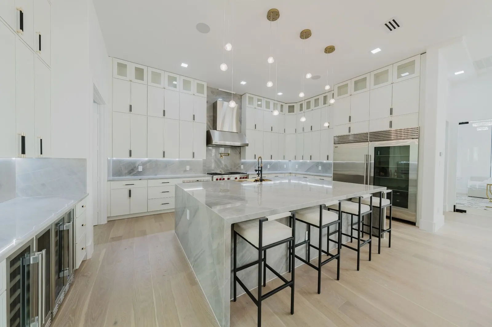 The chef's kitchen: a long marble island, Sub-Zero and Wolf