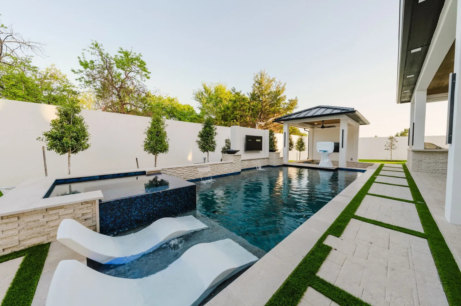 The resort pool at the water's edge, loungers along the deck